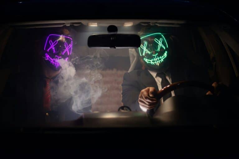 Deux personnes portent des masques lumineux en voiture