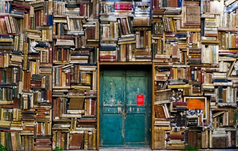 Une porte est entourée de livres qui forment un mur