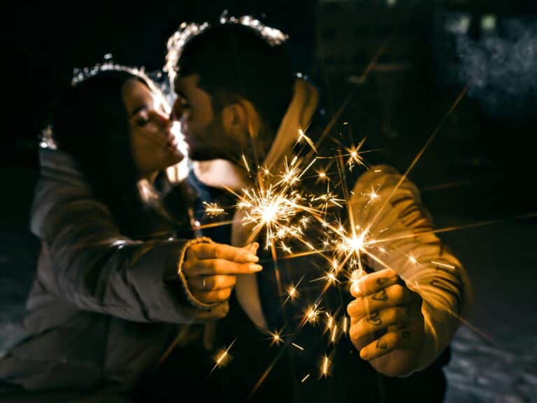 Un couple s'embrasse avec des bougies à la main