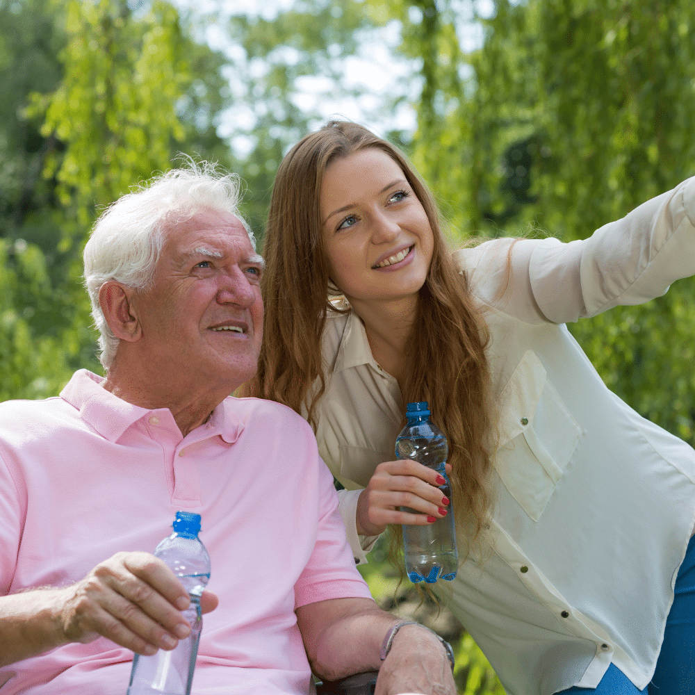 Une jeune femme montre quelque chose à un homme agé