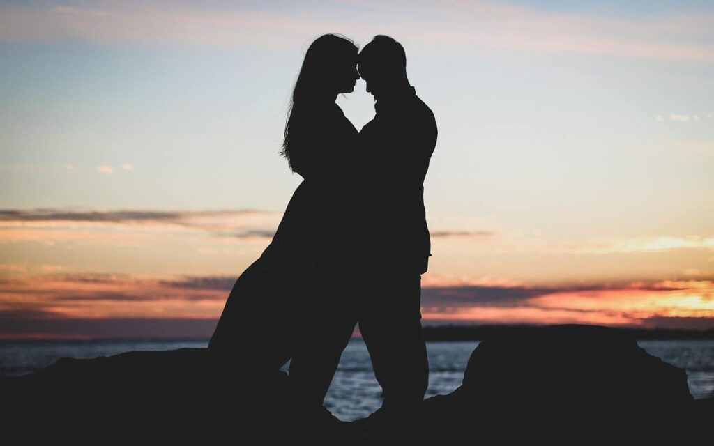 Un couple est proche au coucher de soleil