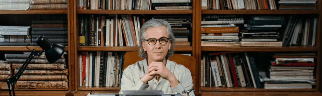 Un homme est assis devant une bibliothèque