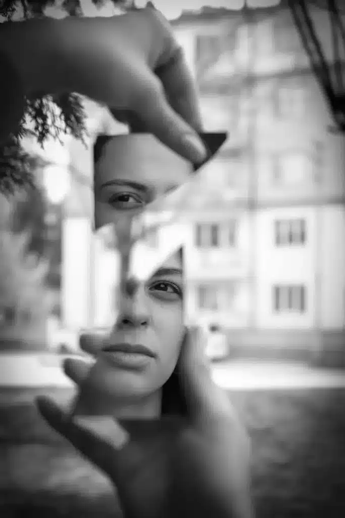 Un miroir est cassé en deux et reflète le visage d'une femme