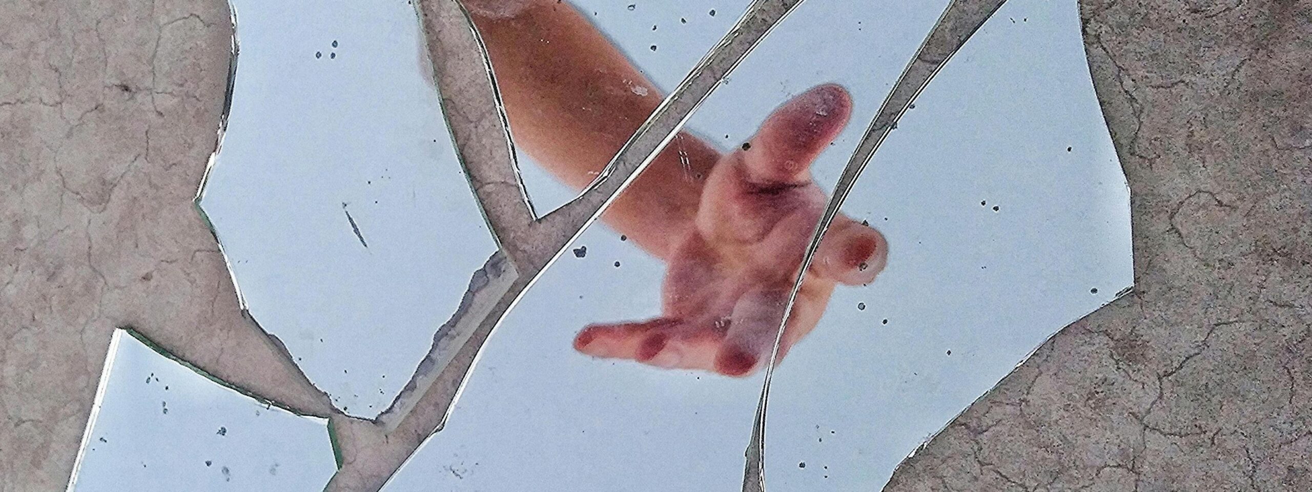 Un miroir brisé avec une main tendue