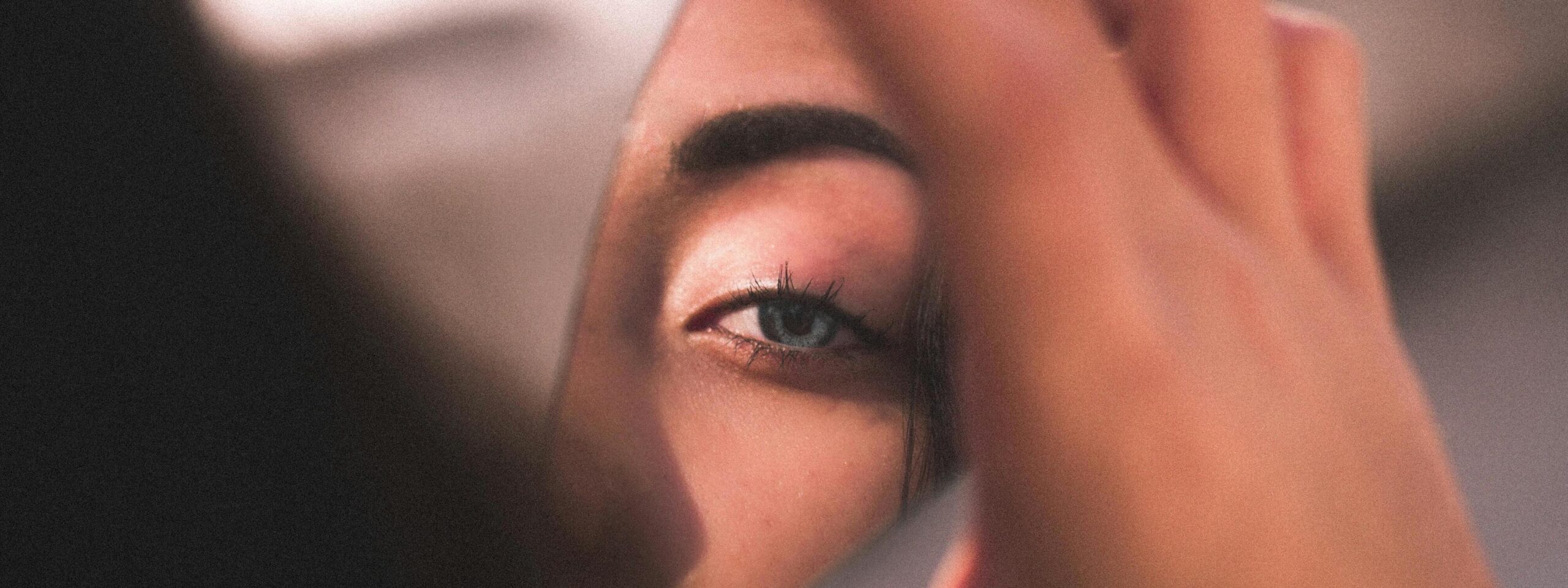 Une femme se regarde dans un miroir brisé