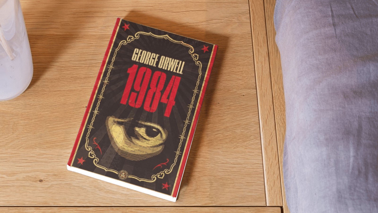 Le livre 1984 de Georges Orwell posé sur un sol en bois