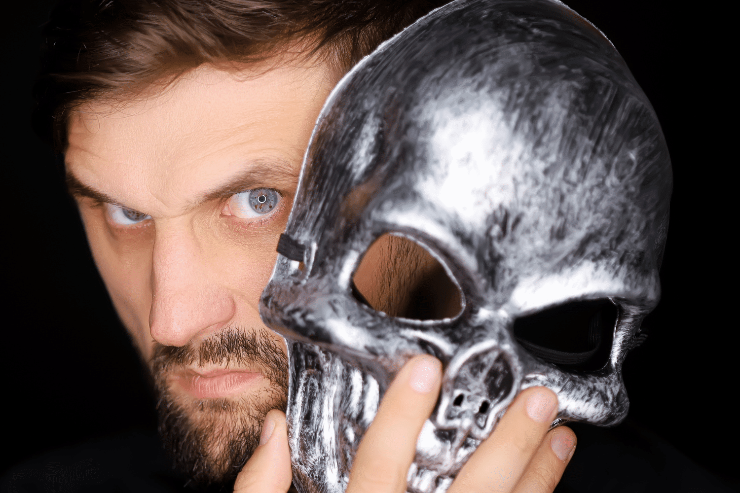 Un homme aux airs inquiétants avec un masque tête de mort argenté