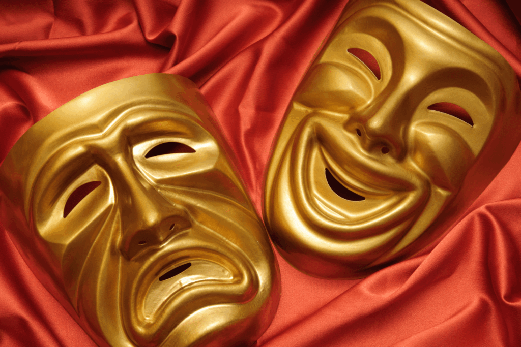 Deux masques dorés, un souriant un pleurant sur une toile rouge