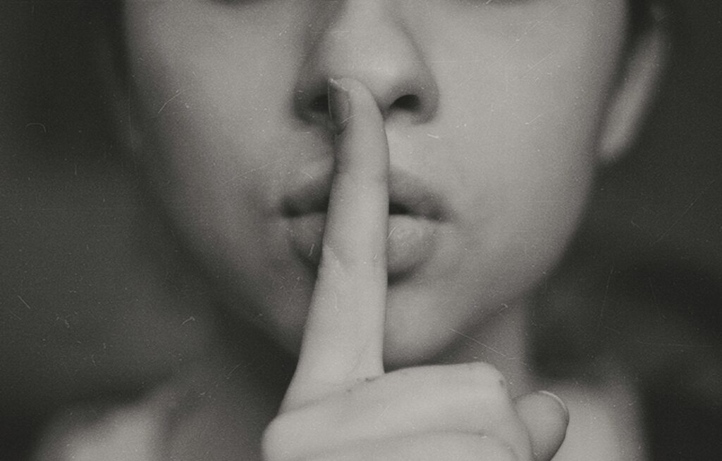 Une femme tient fait le signe silence