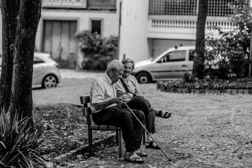 Un couple de vieilles personnes est assis sur un banc en parlant