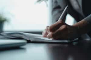 Une personne écrit dans un cahier