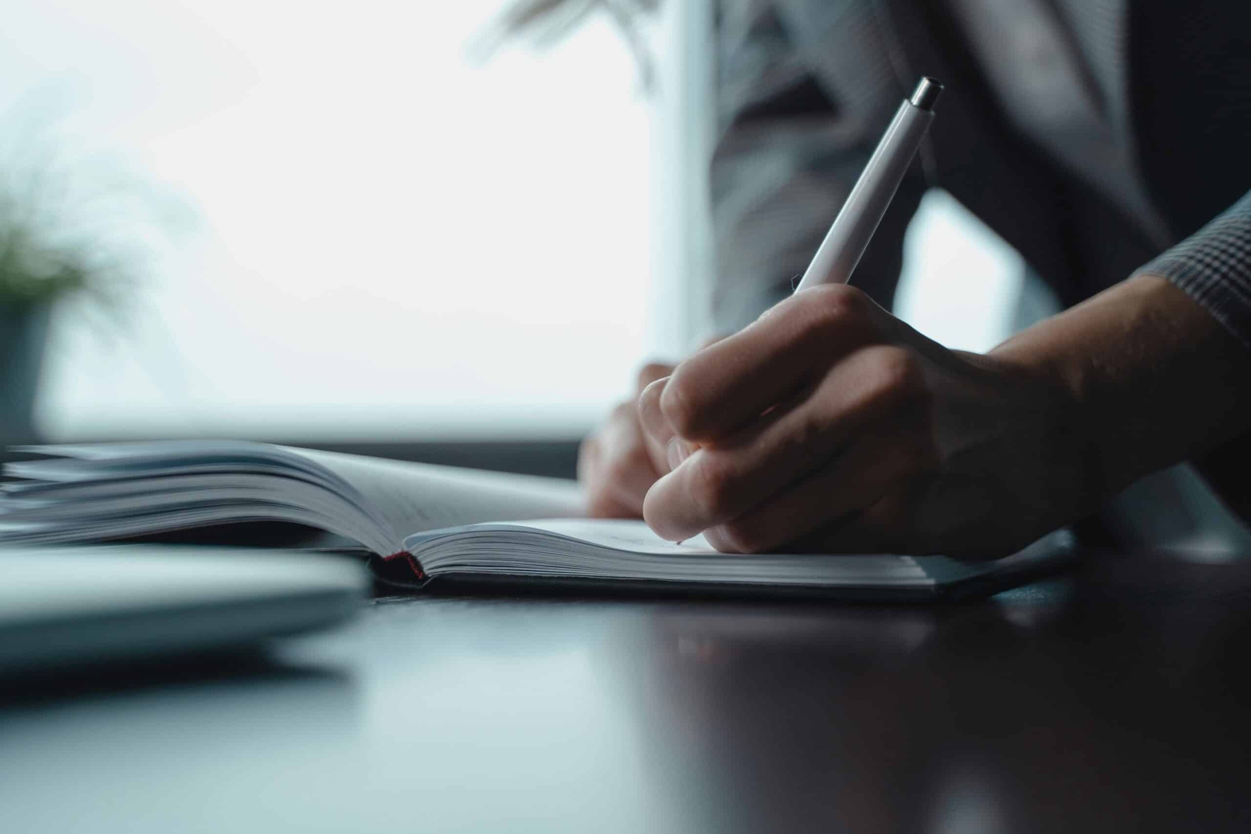 Une personne écrit dans un cahier