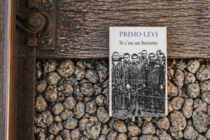 Le livre Si C'est Un Homme de Primo Lévi posé sur les rails d'un train
