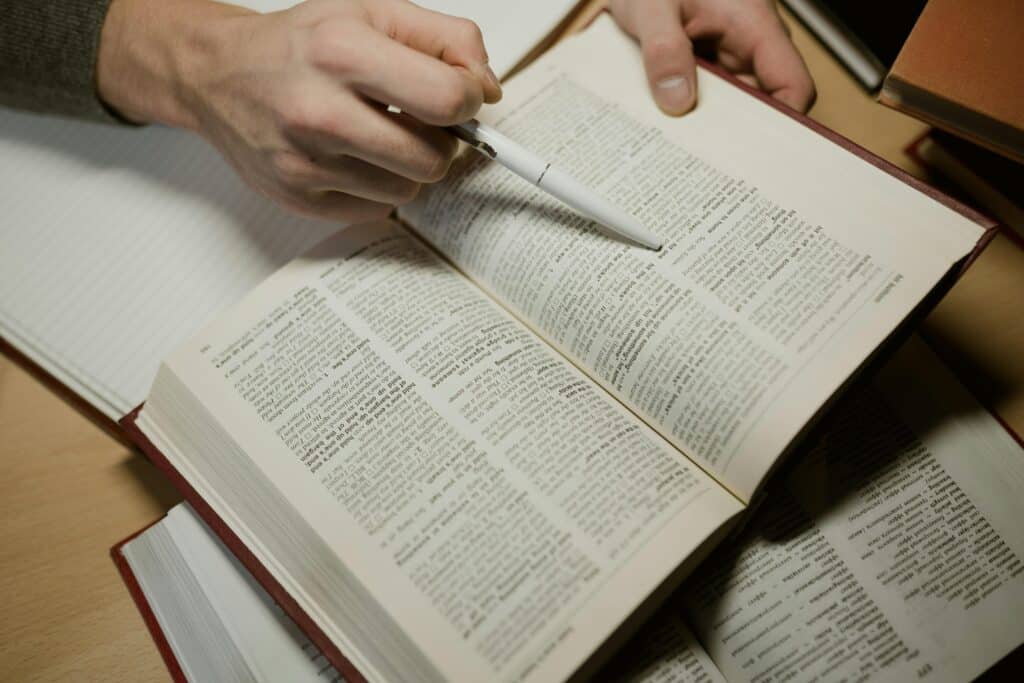 Une personne lit avec un stylo dans un dictionnaire