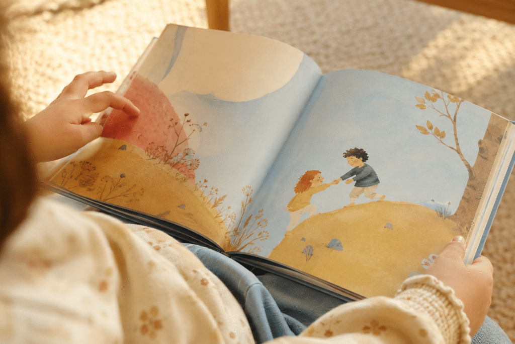 Une petite fille qui lit un livre avec des illustrations.