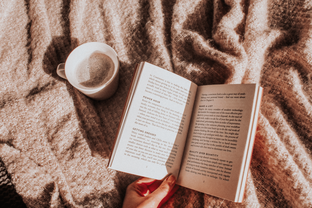Un livre ouvert et une tasse de café sur un plaid