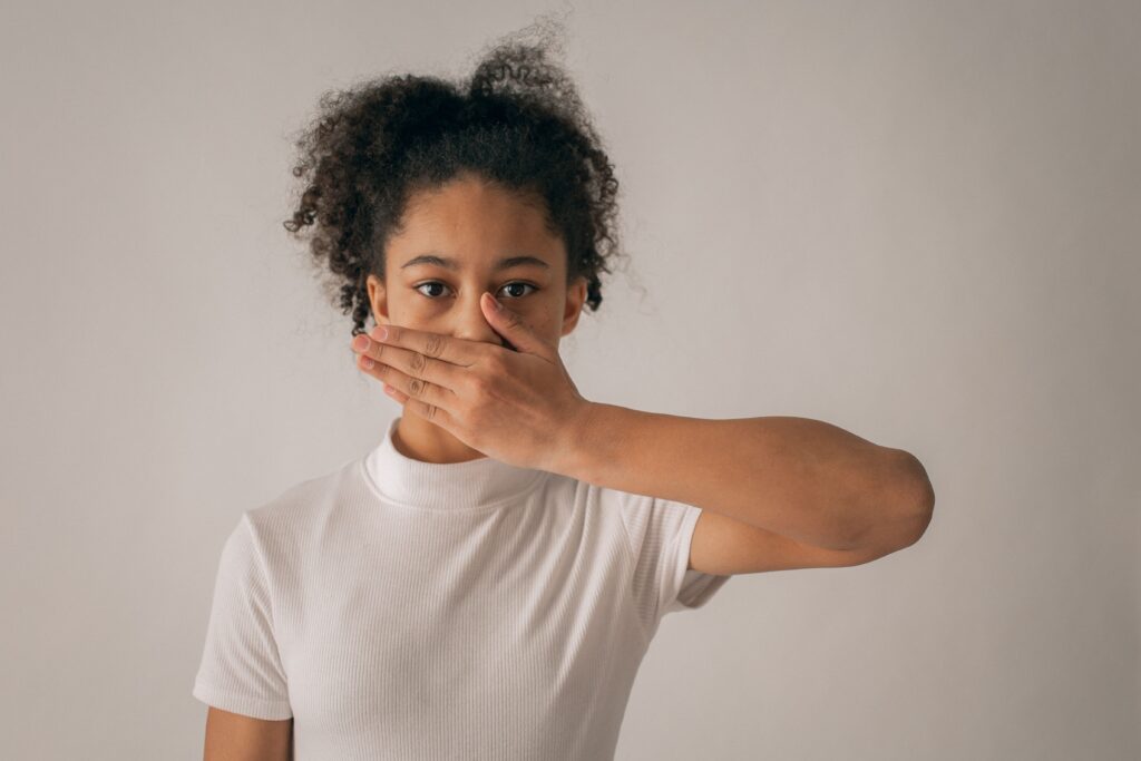 Une jeune femme qui se cache la bouche.