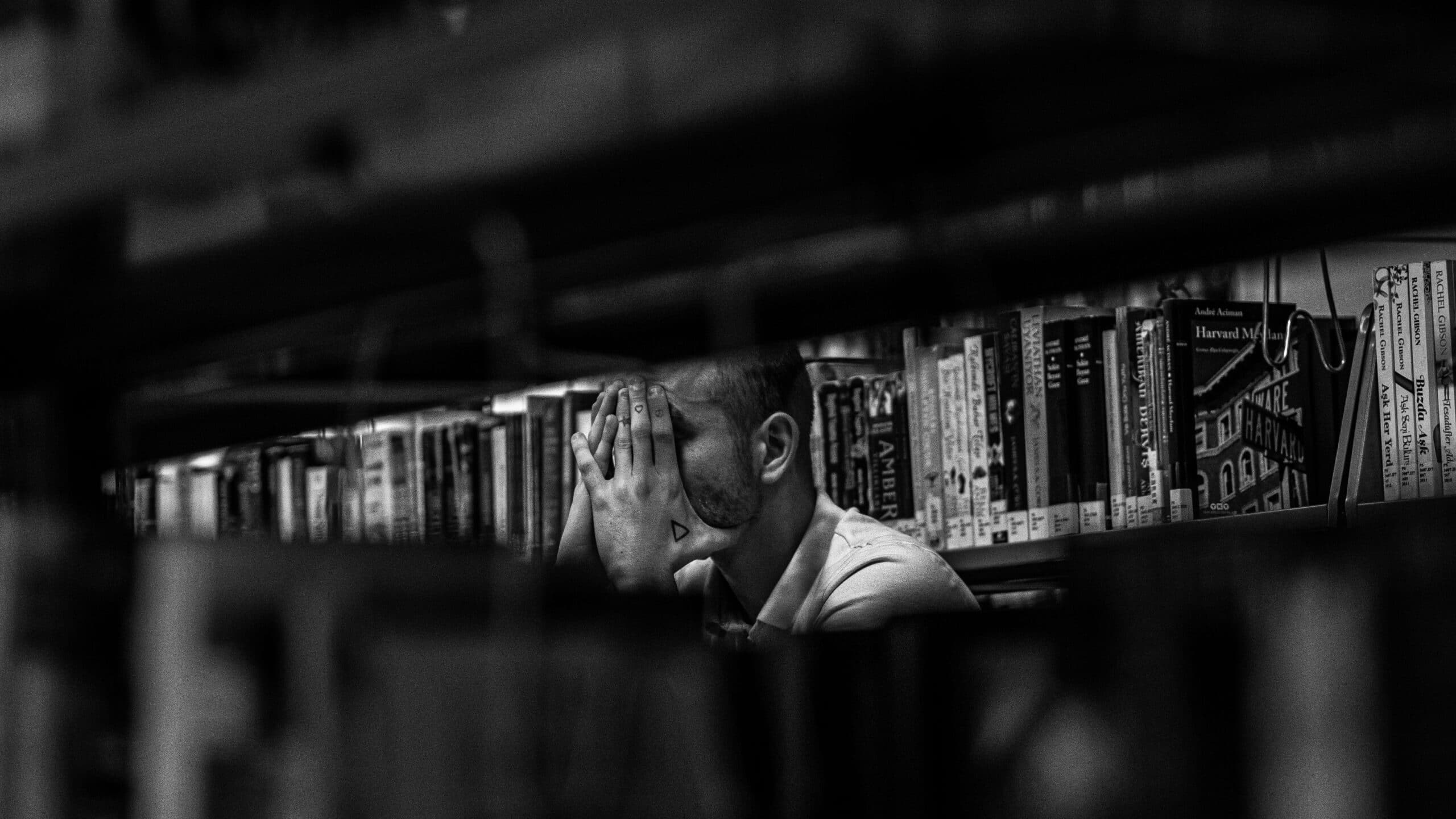 Un homme qui est dans l'inconfort à la bibliothèque.