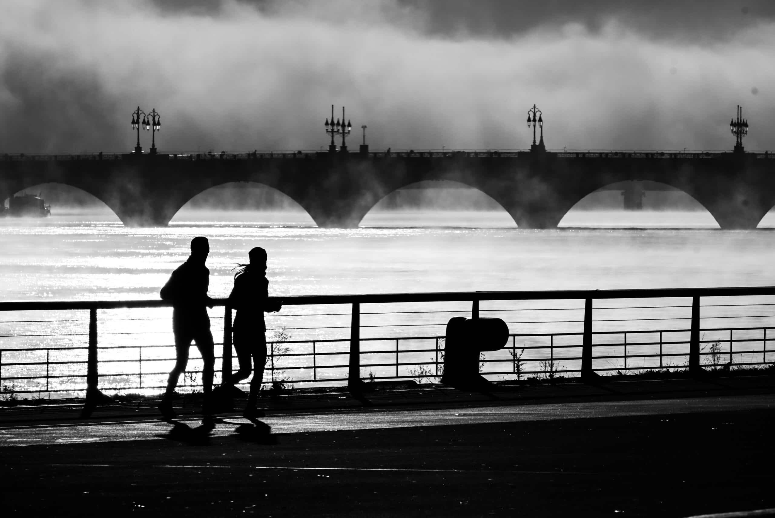 Deux personnes faisant un jogging au bord de l'eau.