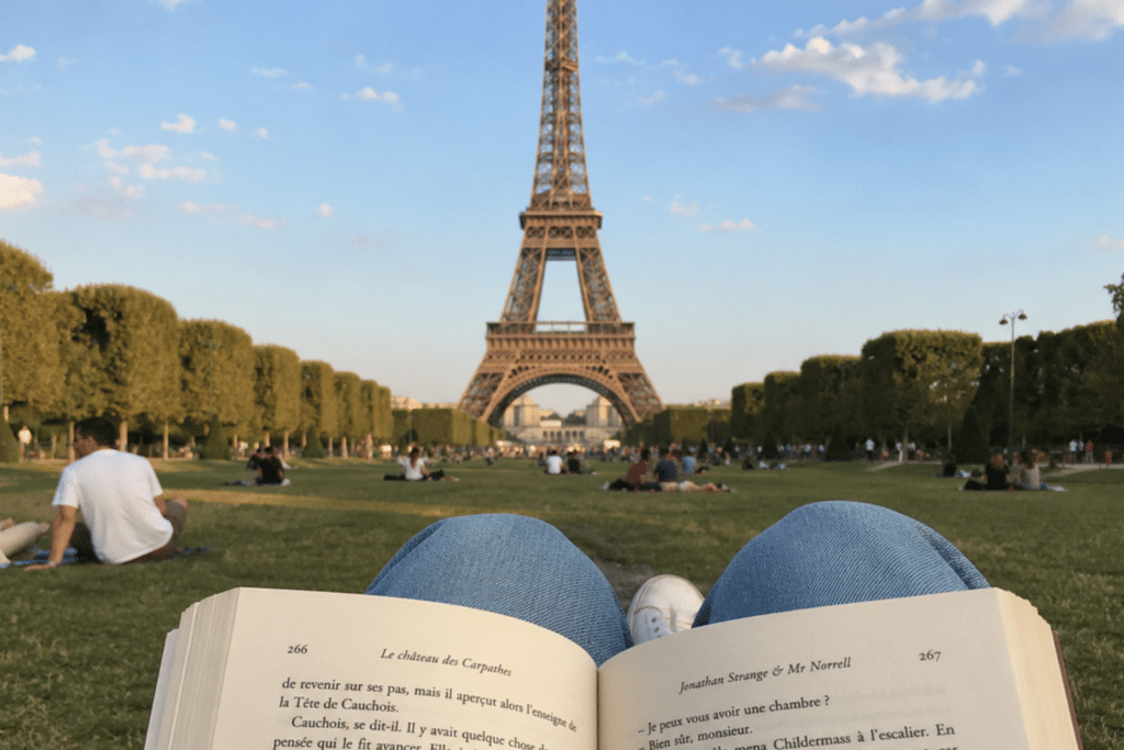 Une personne lit un livre devant la tour eiffel