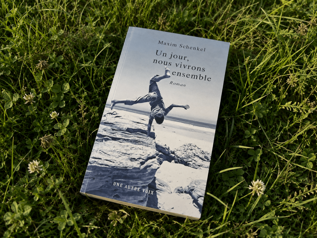 Le livre Un Jour nous Vivrons Ensemble de Maxim Schenkel dans de l'herbe fraiche